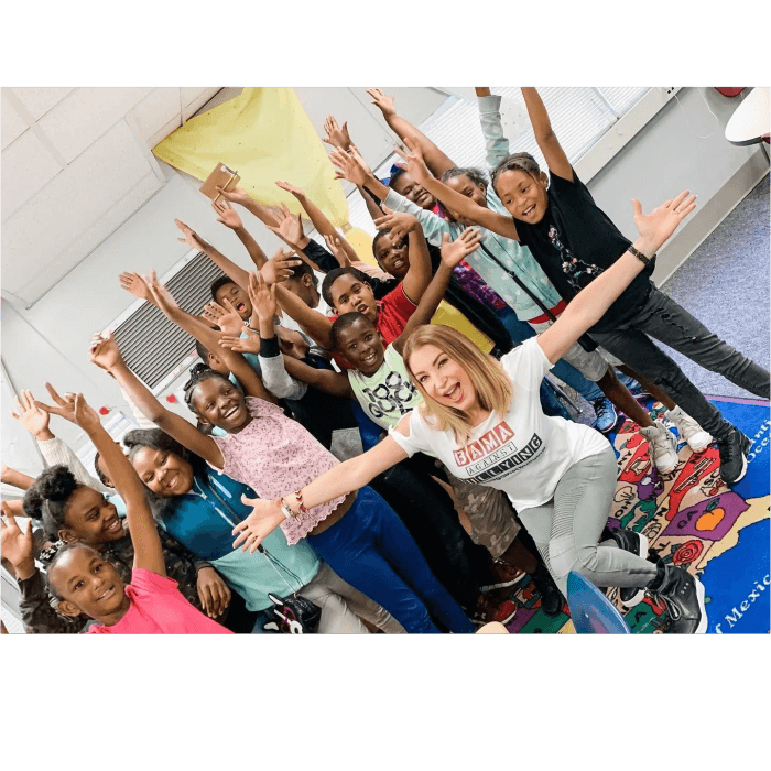 Students with arms raised during a Bama Against Bullying school visit